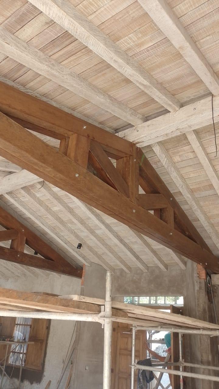 Detalle interior de vigas y tablilla en techo terminado — construcción en madera